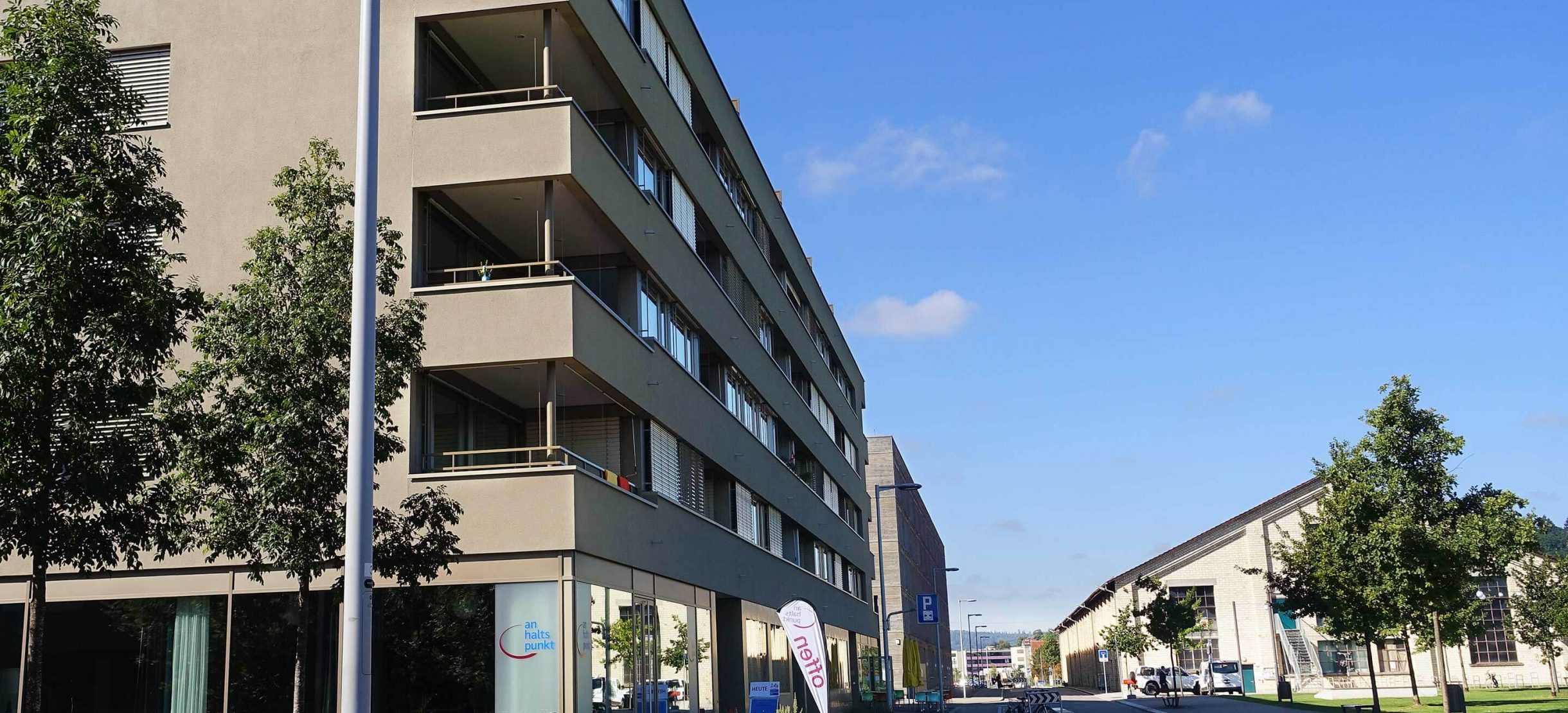 Strasse vor der Halle 710 mit Wohn- und Gewerbegebäuden.